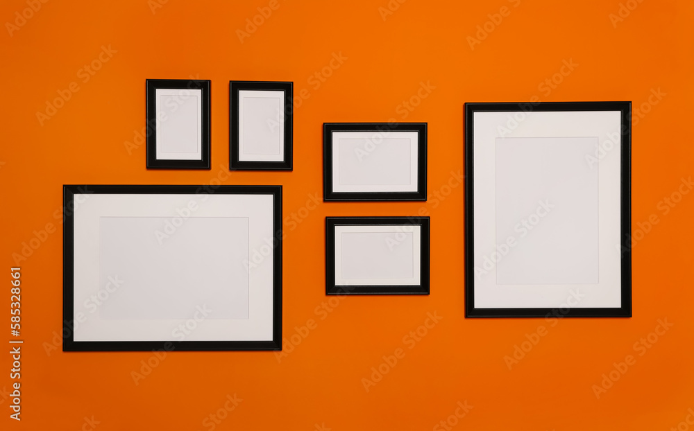 Empty frames hanging on orange wall. Mockup for design Empty frames hanging on orange wall. Mockup for design