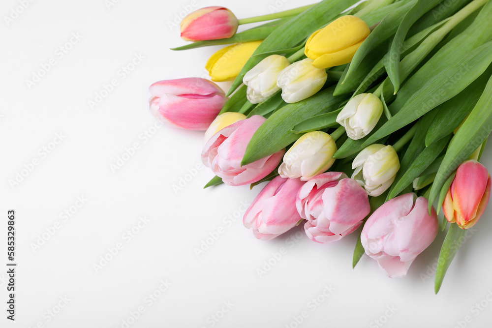Obraz premium Beautiful colorful tulips on light background, closeup. Space for text