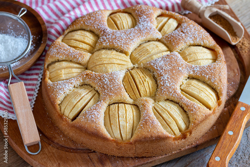 Versunkener Apfelkuchen mit Vollkornmehl und zuckerfrei auf einem Holzbrett photo