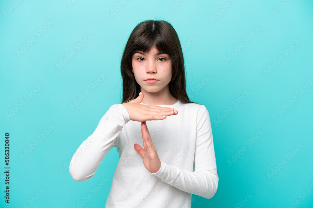 Little caucasian girl isolated on blue background making time out gesture Little caucasian girl isolated on blue background making time out gesture