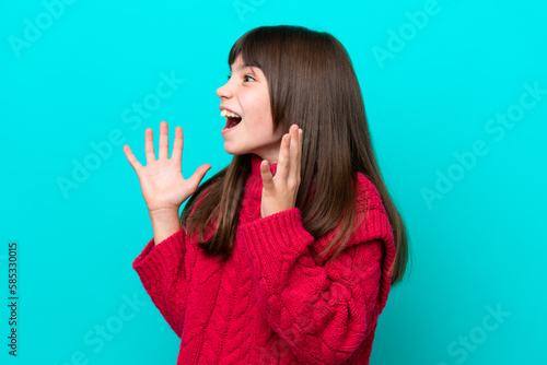 Little caucasian girl isolated on blue background with surprise facial expression