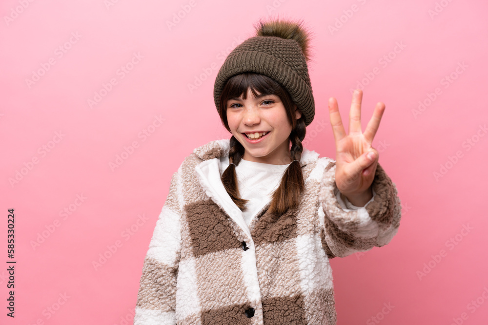 Little caucasian girl with winter jacket isolated on pink background happy and counting three with fingers Little caucasian girl with winter jacket isolated on pink background happy and counting three with fingers