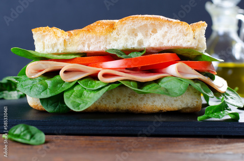 Focaccia Sandwich with Ham, Tomatoes, and Spinach, Sandwich with Italian Flat Bread on Wooden Background