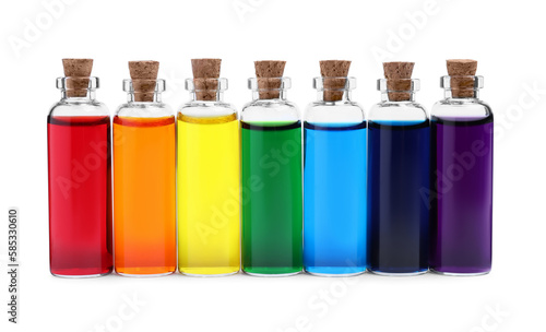 Glass bottles with different food coloring on white background