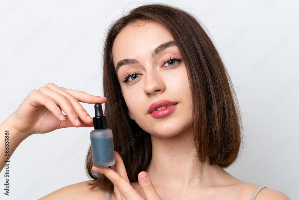 Young Ukrainian woman isolated on white background holding a serum. Close up portrait Young Ukrainian woman isolated on white background holding a serum. Close up portrait