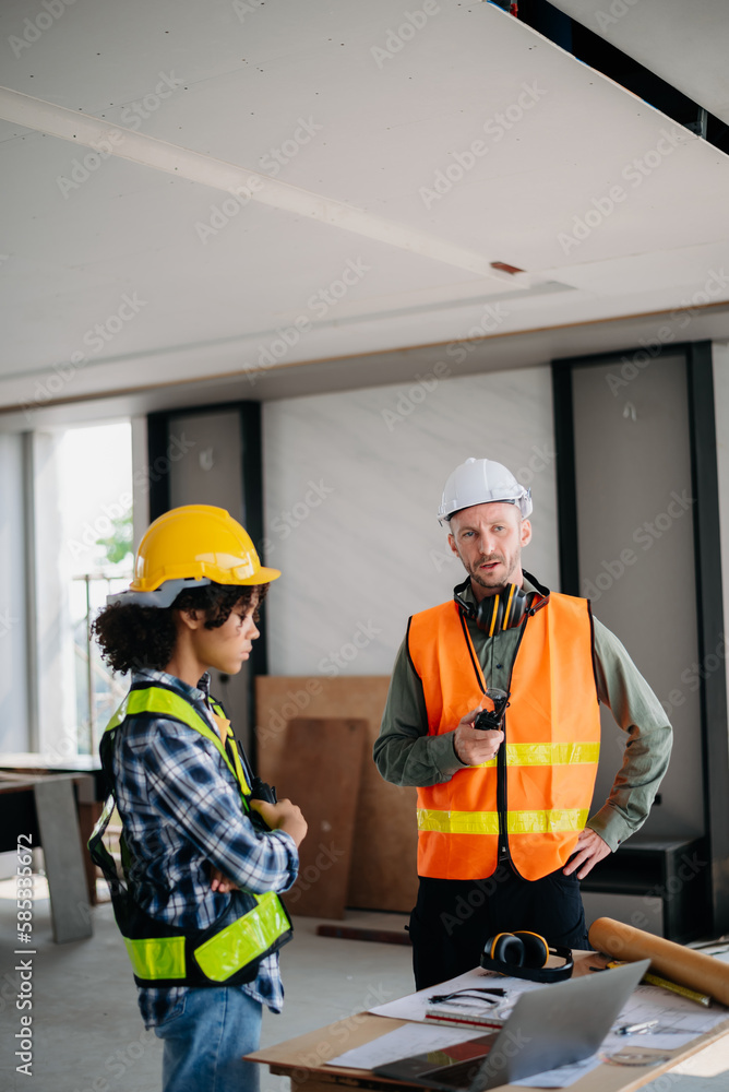 Architect caucasian man working with colleagues mixed race in the construction site. Architecture engineering on big project. Building in construction interior. Architect caucasian man working with colleagues mixed race in the construction site. Architecture engineering on big project. Building in construction interior.
