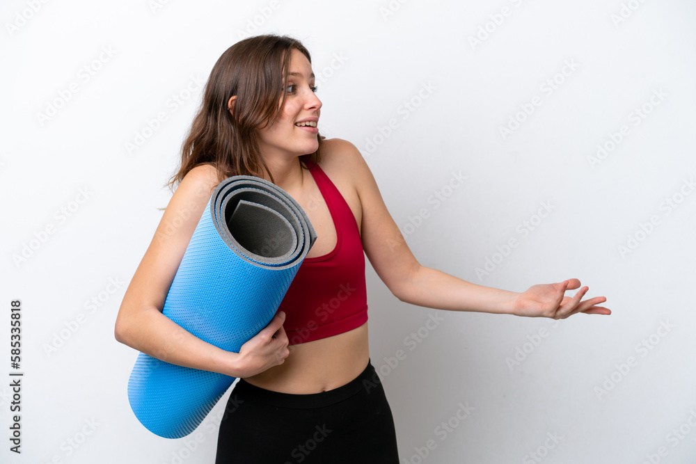 Young sport caucasian woman going to yoga classes while holding a mat isolated on white background with surprise expression while looking side Young sport caucasian woman going to yoga classes while holding a mat isolated on white background with surprise expression while looking side