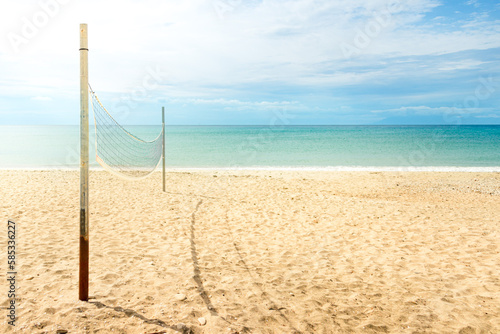 Obraz na płótnie Beach volleyball net on a golden sand beach with turquoise sea waters and bright blue sunny sky w salonie