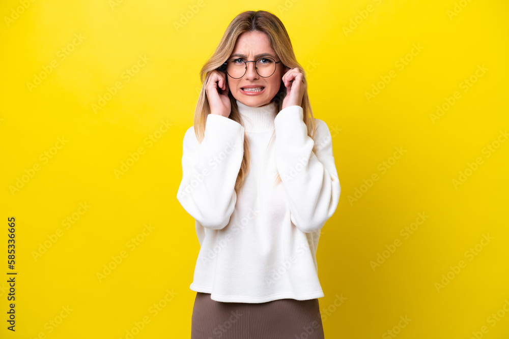 Young Uruguayan woman isolated on yellow background frustrated and covering ears Young Uruguayan woman isolated on yellow background frustrated and covering ears