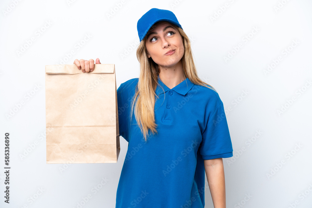 Young Uruguayan woman taking a bag of takeaway food isolated on white background and looking up Young Uruguayan woman taking a bag of takeaway food isolated on white background and looking up