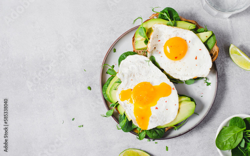 Avocado Sandwich with Fried Egg, Spinach and Green Sprouts, Healthy Breakfast or Snack on Bright Background
