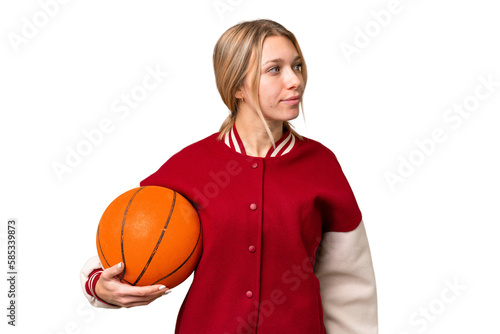 Young hispanic woman playing basketball over isolated white background looking to the side
