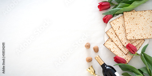 white big banner Matzah shape of heart with red tulips, bottle of wine and walnut on white background. Traditional Holiday on Passover. Home symbol of lovely Jewish family in pesach. top view