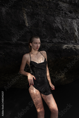 Sexy woman posing on stone rocks on beach