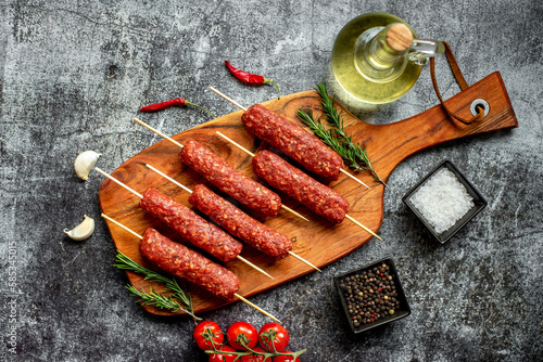 Homemade lula kebab from raw meat on a stone background