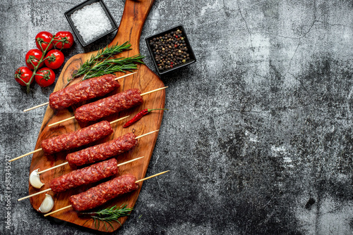 Homemade lula kebab from raw meat on a stone background with copy space for your text