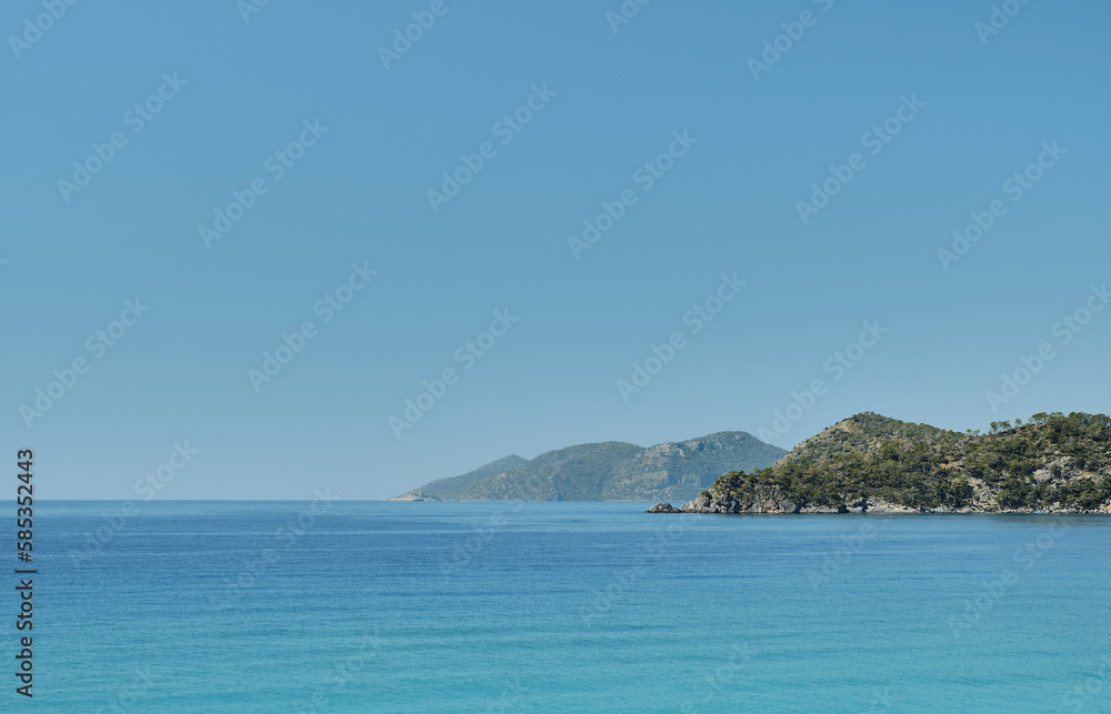 Beautiful view of the blue sea and islands in a deserted place on the coast of the sea, blue clear sky on a sunny day. Summer tropical vacation on the Aegean Sea, panoramic view. Beautiful view of the blue sea and islands in a deserted place on the coast of the sea, blue clear sky on a sunny day. Summer tropical vacation on the Aegean Sea, panoramic view.