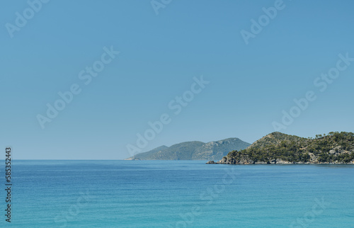 Beautiful view of the blue sea and islands in a deserted place on the coast of the sea, blue clear sky on a sunny day. Summer tropical vacation on the Aegean Sea, panoramic view.