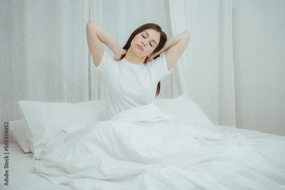 Top view of attractive young smiling woman smiling and stretching while lying on the bed at home Top view of attractive young smiling woman smiling and stretching while lying on the bed at home