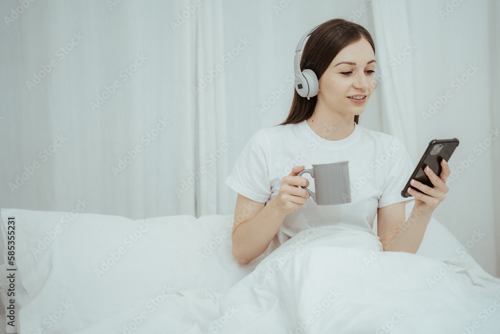 Beautiful girl at her bedroom drinking tea in the morning. Beautiful girl at her bedroom drinking tea in the morning.