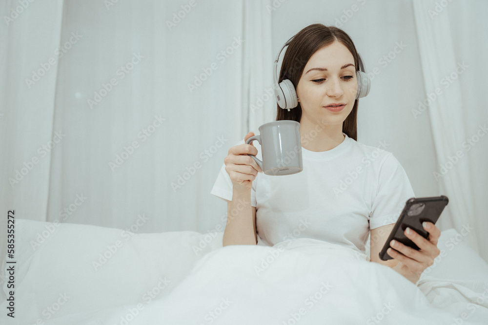 Beautiful girl at her bedroom drinking tea in the morning. Beautiful girl at her bedroom drinking tea in the morning.