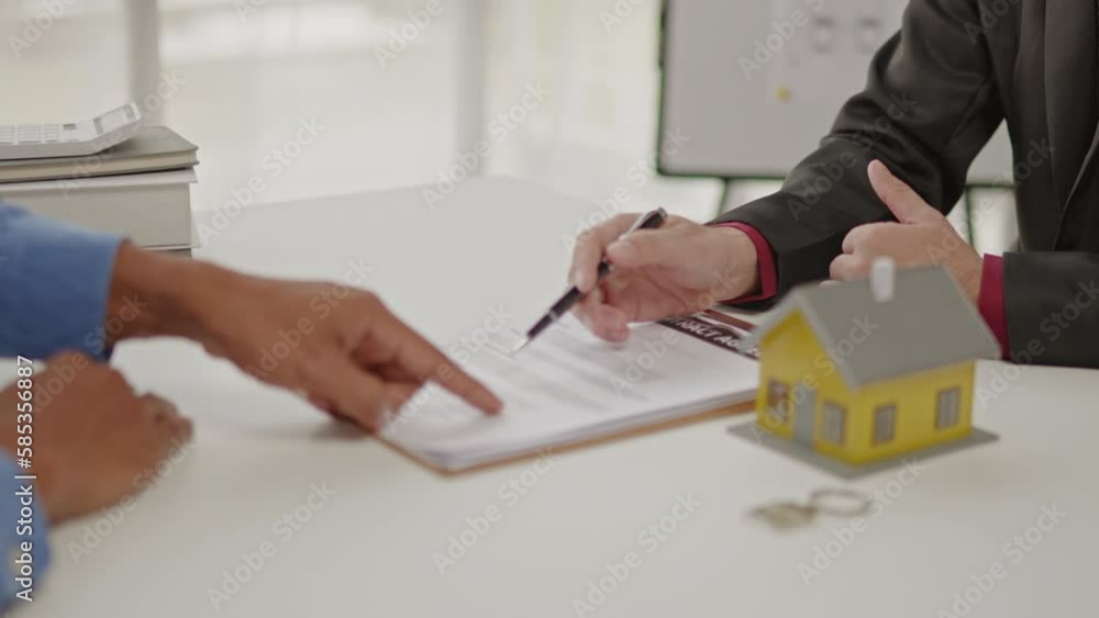 Close up of business's hands selling and signing agreement paperwork for loan financial to buying the house properties. Close up of business's hands selling and signing agreement paperwork for loan financial to buying the house properties.
