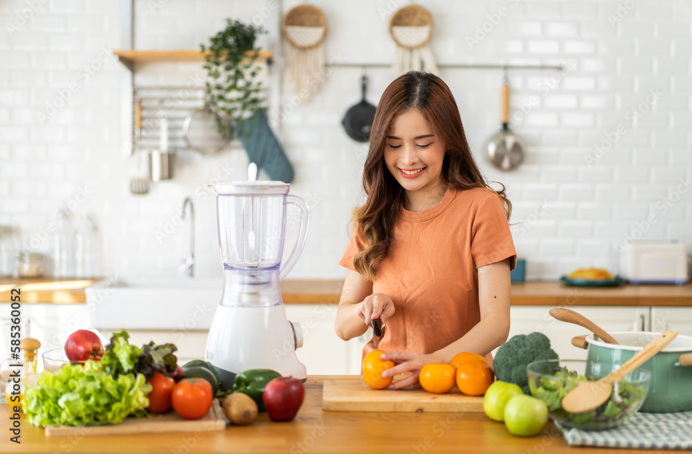 Portrait of beauty body slim healthy asian woman drinking glass of juice and orange.young girl preparing cooking healthy drink with fresh orange juice in kitchen at home.Diet concept.healthy drink