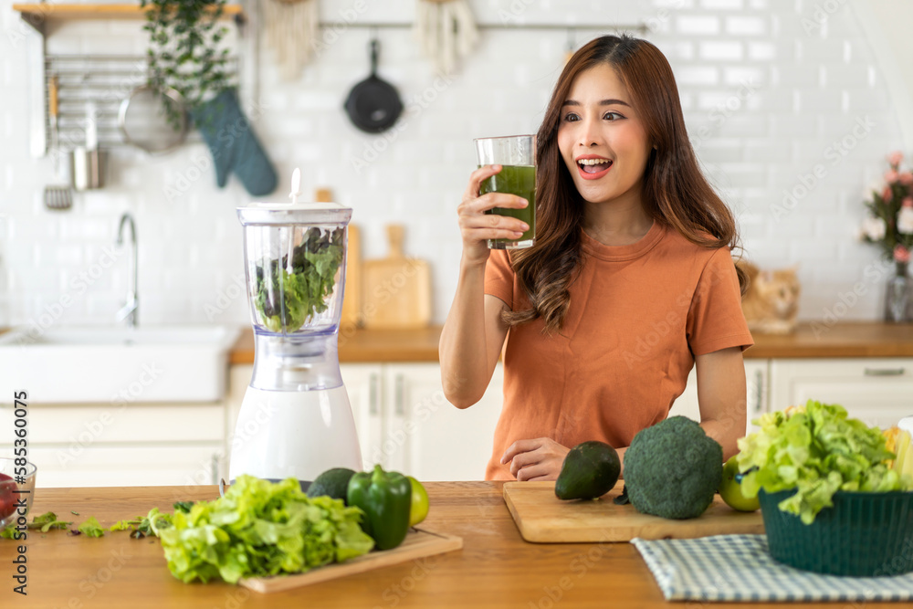 Portrait of beauty healthy asian woman making green vegetables detox vegan and green fruit smoothie with blender.young girl drinking glass of green fruit smoothie in kitchen.Diet concept.healthy Portrait of beauty healthy asian woman making green vegetables detox vegan and green fruit smoothie with blender.young girl drinking glass of green fruit smoothie in kitchen.Diet concept.healthy