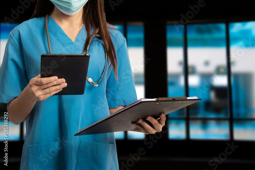 Obraz na plátně Doctor using clipboard and digital tablet find information patient medical history at the hospital