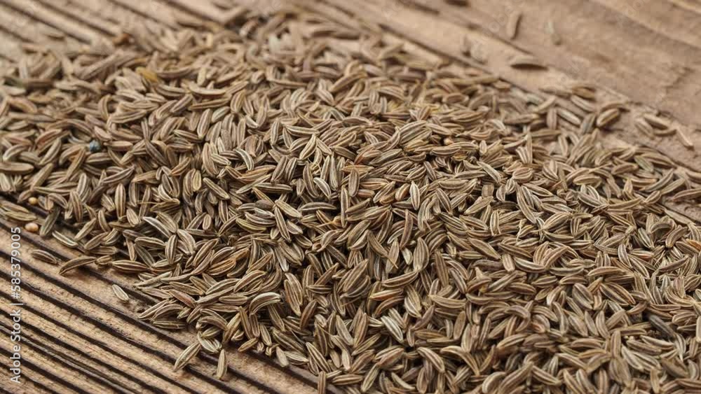 Aromatic cumin dry seeds texture on a wooden table Aromatic cumin dry seeds texture on a wooden table