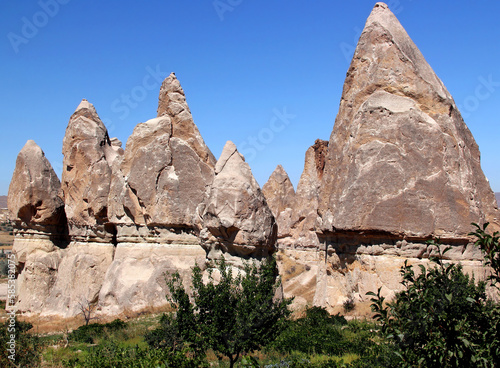Landscape with many rocks in the shape of mushrooms (also called Fairy Chimneys) in the Rose Valley between the towns of Goreme and Cavusin in Cappadocia, Turkey