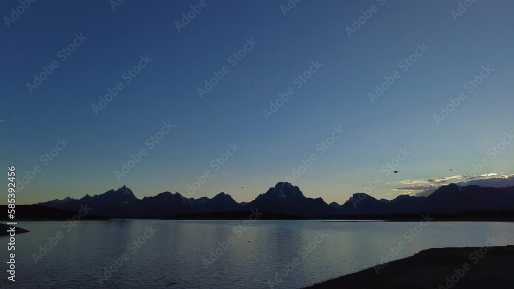 Birds Fly Over Jackson Lake at Dusk in Grand Teton National Park Birds Fly Over Jackson Lake at Dusk in Grand Teton National Park