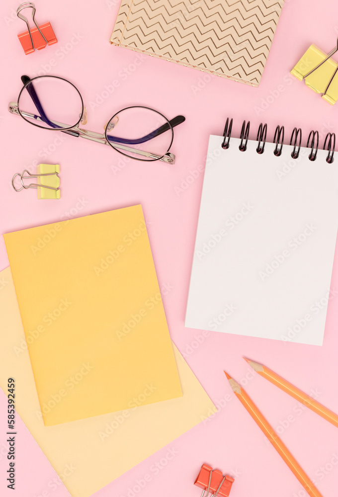 School supplies and eyeglasses on a pink background. Clean notepad. School supplies and eyeglasses on a pink background. Clean notepad.
