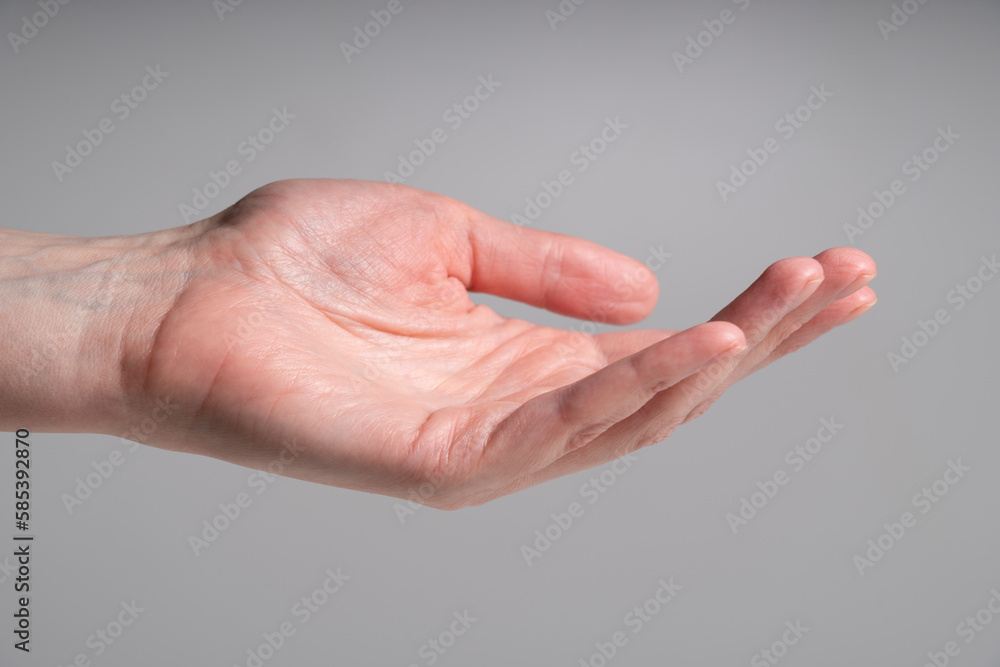 Closeup of human open hand palm on grey background