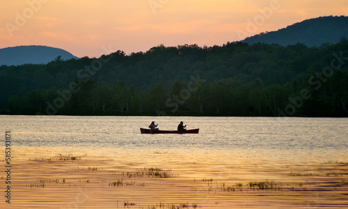 Silhouette of two people in a canoe at sunset