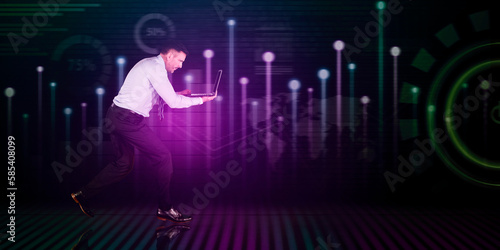 Businessman with laptop running with technology background