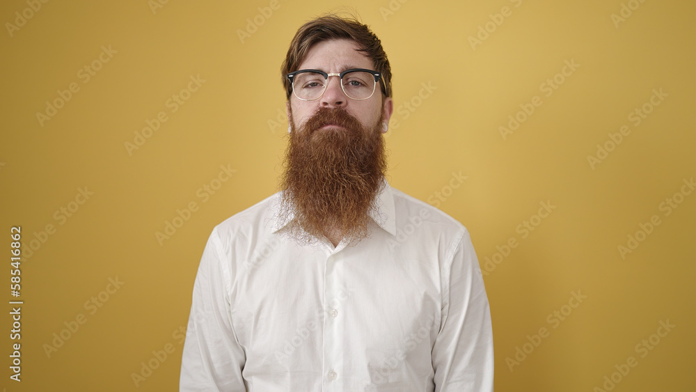 Young redhead man wearing glasses with relaxed expression over isolated yellow background Young redhead man wearing glasses with relaxed expression over isolated yellow background
