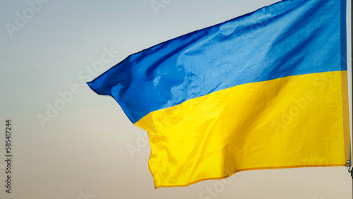 Close-up National flag of Ukraine waving against the wind in the sky of sunrise or sunset outdoors background. Concept of Peace, Ukraine flag. Freedom, Symbol, Independence Day, Pray for Ukraine