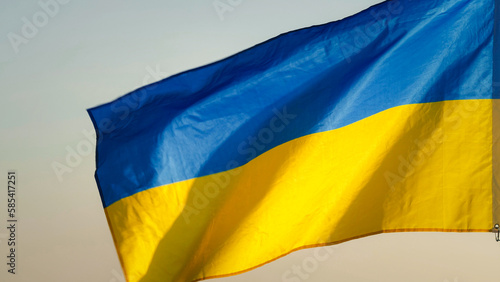 Close-up National flag of Ukraine waving against the wind in the sky of sunrise or sunset outdoors background. Concept of Peace, Ukraine flag. Freedom, Symbol, Independence Day, Pray for Ukraine