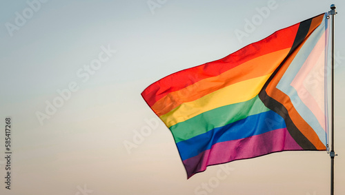 LGBT History Month, Pride Month, LGBT Lesbian, Gay, Bisexual, Transgender, Queer or Questioning, Parade Concept. Six-band Rainbow flag waving in wind,  outdoor background, soft focus. Slow motion
