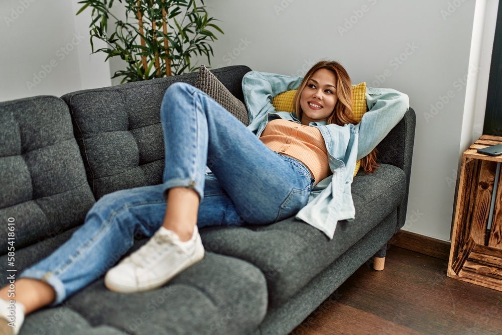 Obraz premium Young caucasian woman smiling confident lying on sofa at home