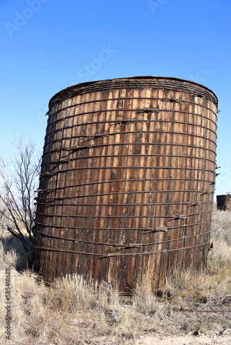Large wood crude oil storage tank with vertical wood slats and steel ring binders