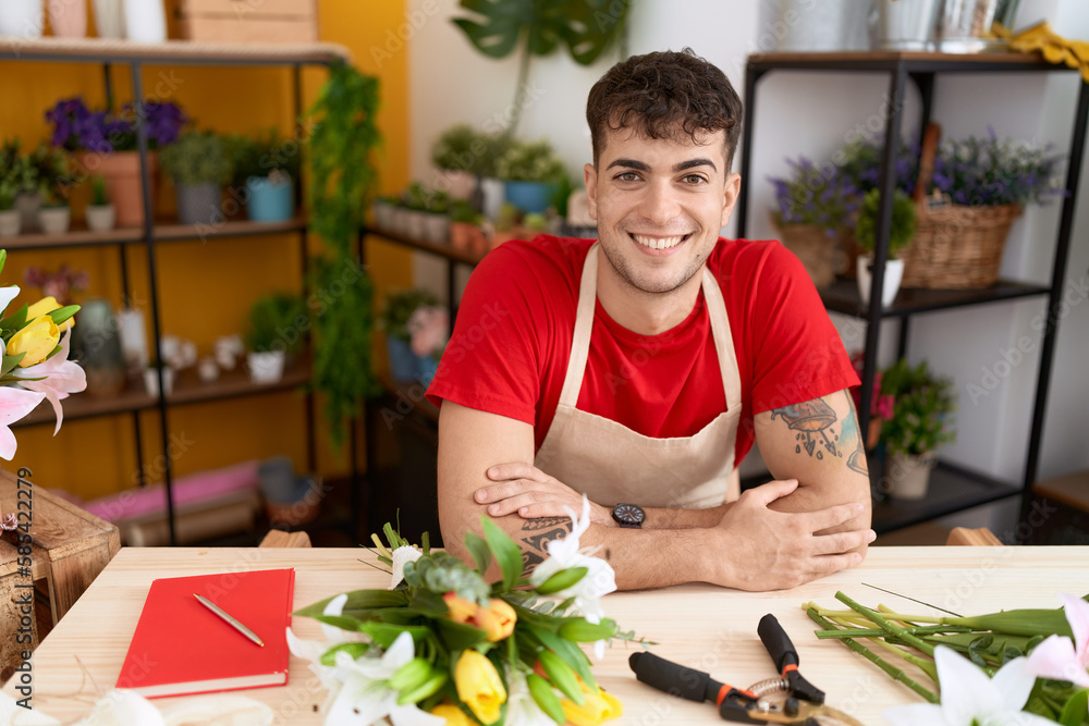 Young hispanic man florist smiling confident sitting with arms crossed gesture at flower shop Young hispanic man florist smiling confident sitting with arms crossed gesture at flower shop