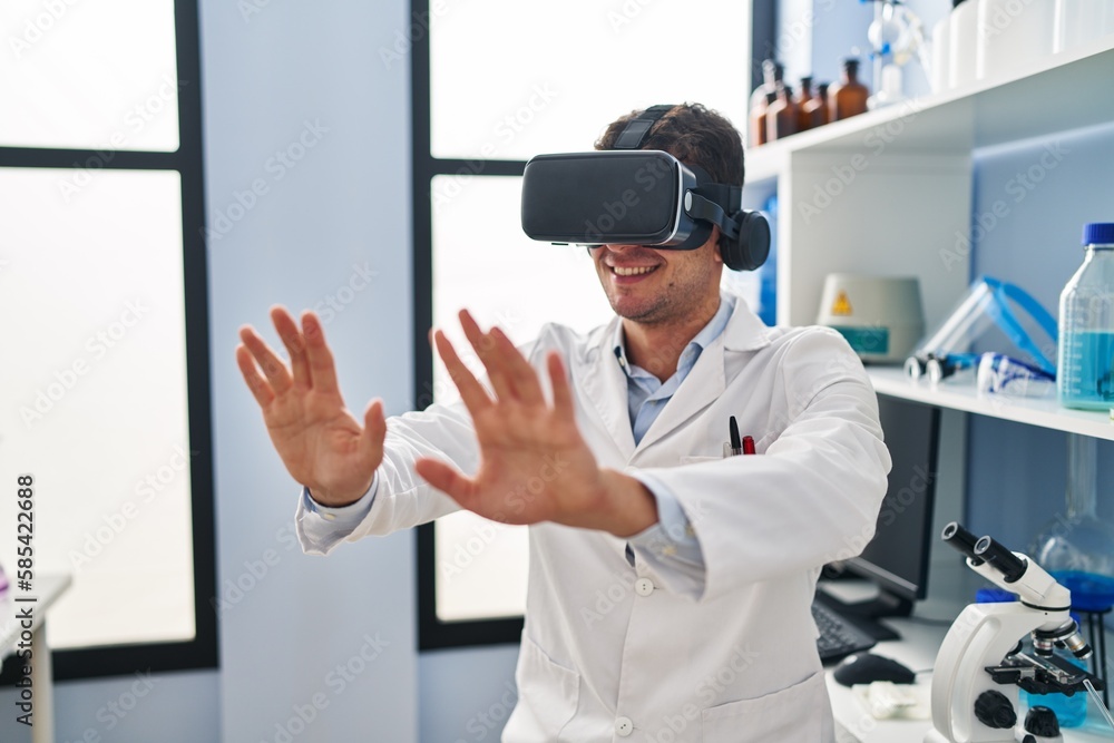 Young hispanic man scientist using virtual reality glasses at laboratory
