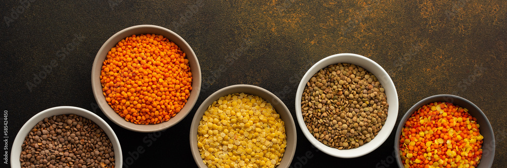 Multicolored lentils in bowls banner, yellow and brown, green and orange lentils, healthy legumes, top view, copy space Multicolored lentils in bowls banner, yellow and brown, green and orange lentils, healthy legumes, top view, copy space