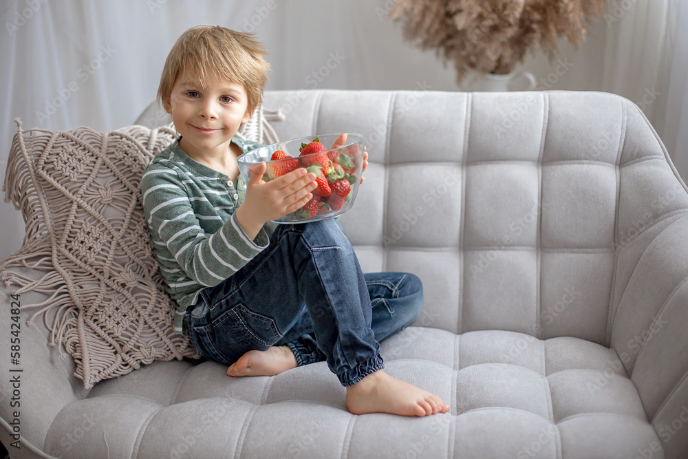 Cute preschool child, boy, eating strawberries at home Cute preschool child, boy, eating strawberries at home