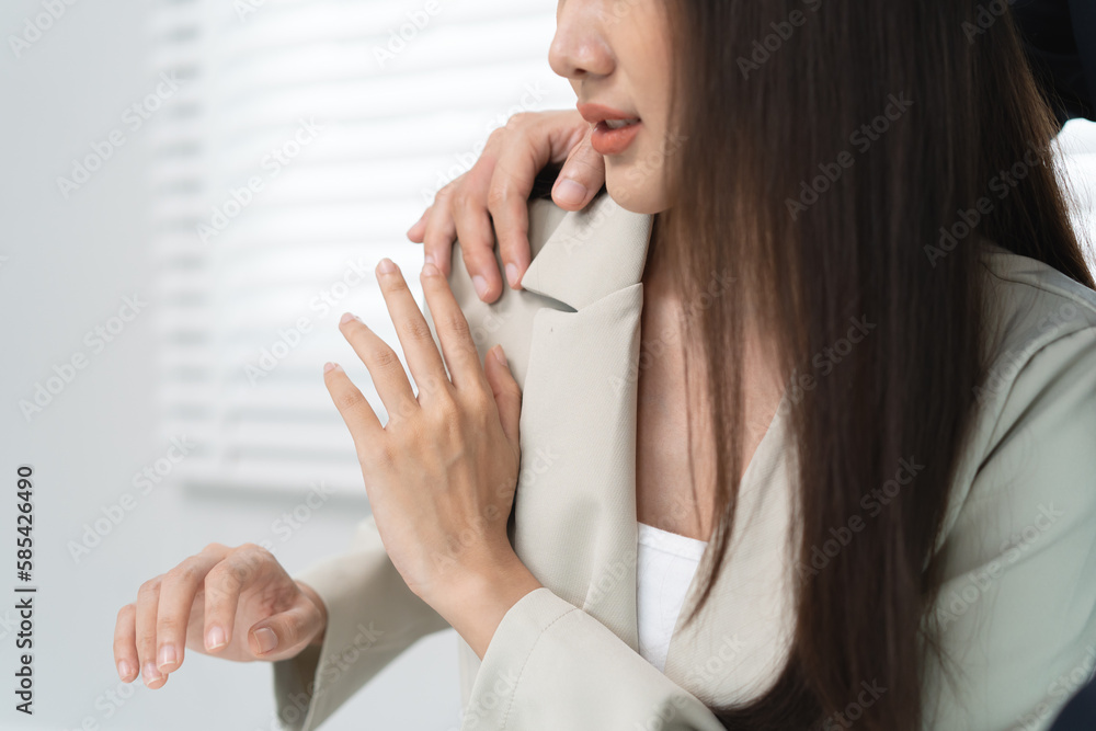 Sexsual harassment in workplace. Unhappy female employee looking at hand of boss touch at her shoulder and feeling disgusted. Sexsual harassment in workplace. Unhappy female employee looking at hand of boss touch at her shoulder and feeling disgusted.