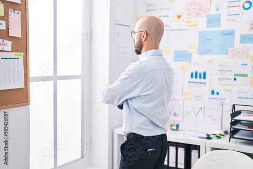 Young bald man business worker looking throw the window at office