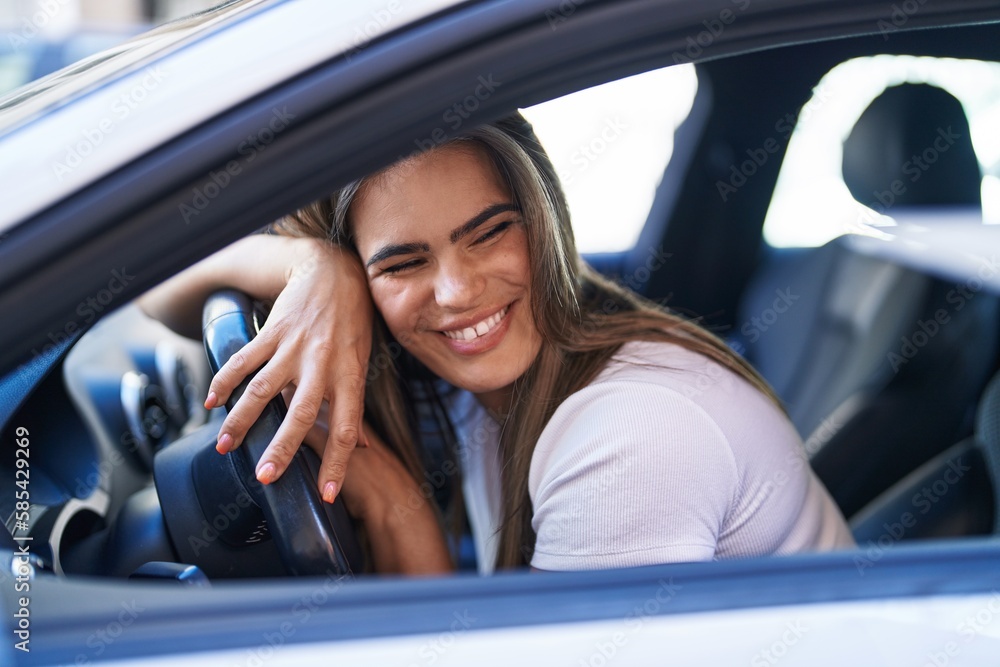 Young woman smiling confident driving car at street