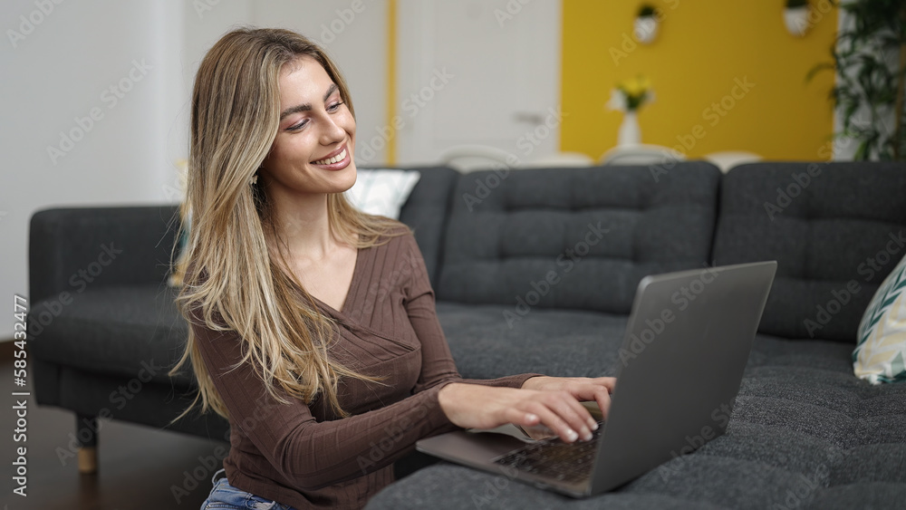 Young blonde woman using laptop sitting on floor at home Young blonde woman using laptop sitting on floor at home